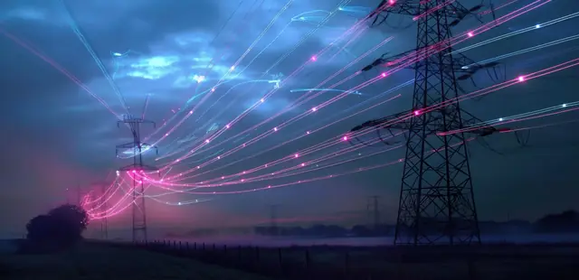 Electricity transmission pylons at dusk with illuminated power lines stretching across open countryside
